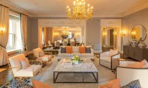 Elegancki salon z marmurowym stolikiem i złotym żyrandolem. Zastanawiasz się, ile kosztuje doba w hotelu Plaza w Nowym Jorku?