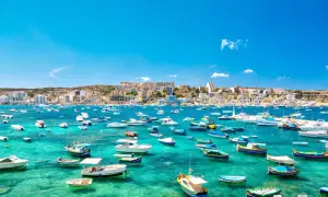 Malta w lutym: słoneczna zatoka pełna łodzi, idealna na spacer.