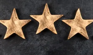 Trzy złote gwiazdki na ciemnym tle. Symbolizują moment, kiedy hotel dostaje gwiazdki, nagrodę za jakość.