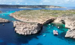 Malta, z jej malowniczymi zatokami i turkusową wodą, jest domem dla około 530 tys. mieszkańców. Widać tu łodzie i klify.