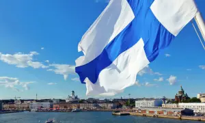 Flaga Finlandii powiewa nad portem w Helsinkach. W tle widać katedrę. Finlandia używa euro, więc to jest waluta, jaką ma Finlandia.