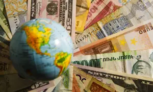 Globus na tle różnych walut. Czy na Malcie można płacić dolarami? To pytanie zadaje sobie wielu podróżnych.