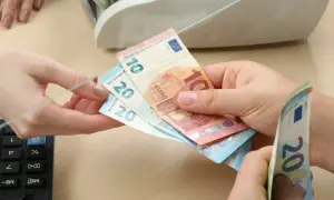 Ręce przekazują sobie banknoty euro. Czy na Węgrzech można płacić euro? Tak, w wielu miejscach można.