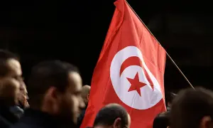 Flaga Tunezji powiewa wśród tłumu. Czy Tunezja jest zagrożona wojną?