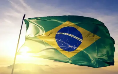 Flaga Brazylii powiewa na tle nieba. Czy jest waluta o nazwie real? Tak, to brazylijska waluta.