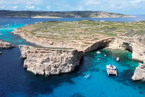 Malta, z jej malowniczymi zatokami i turkusową wodą, jest domem dla około 530 tys. mieszkańców. Widać tu łodzie i klify.