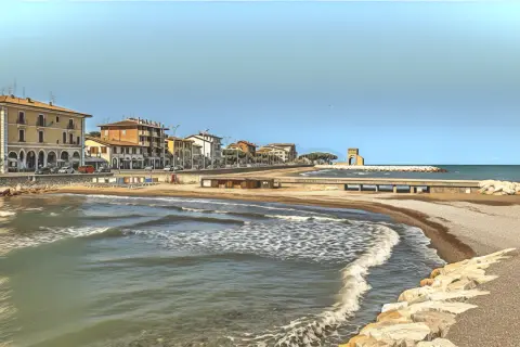 Spokojne morze i plaża w Rimini, z budynkami w tle. Czy Rimini jest bezpieczne? Wygląda na spokojne i przyjazne.