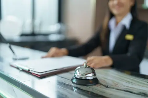 Recepcjonistka w hotelu, przed nią dzwonek i dokumenty. Czy hotel ma prawo żądać dowodu osobistego?