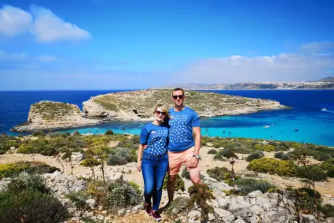 Para na tle turkusowej wody i skalistego krajobrazu Malty. Ile ludności ma Malta? Około 500 tysięcy.