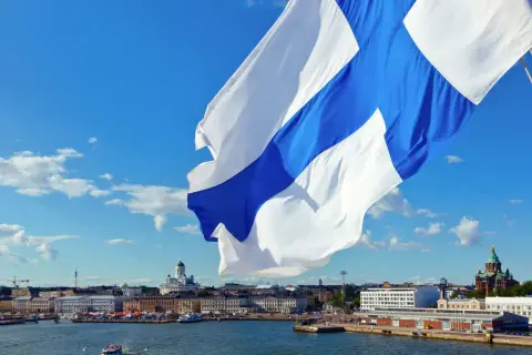 Flaga Finlandii powiewa nad portem w Helsinkach. W tle widać katedrę. Finlandia używa euro, więc to jest waluta, jaką ma Finlandia.