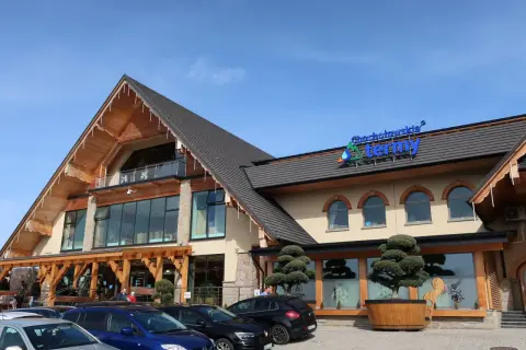Przed Termami Chochołowskimi zaparkowane są samochody. Czy parking na termach chochołowskich jest płatny? Nie wiadomo z tego ujęcia.