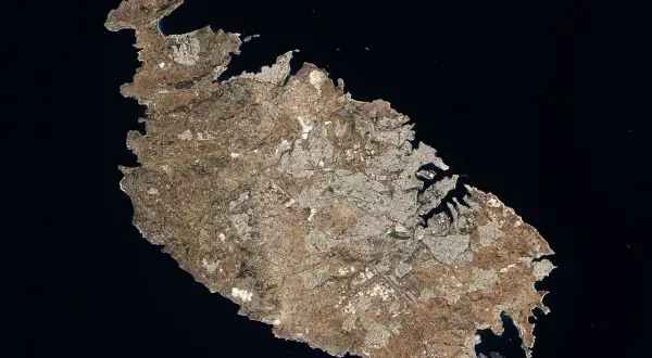 Widok satelitarny Malty, ukazujący gęsto zaludnione obszary miejskie i porty. Widać, ile ludzi ma Malta, skupionych wzdłuż wybrzeża.