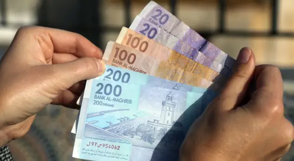 Ręka trzyma marokańskie dirhamy. Czy w Maroko można płacić dolarami? Raczej nie, lepiej mieć lokalną walutę.