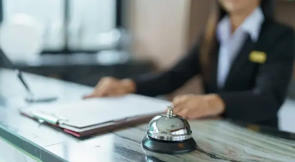 Recepcjonistka w hotelu, przed nią dzwonek i dokumenty. Czy hotel ma prawo żądać dowodu osobistego?