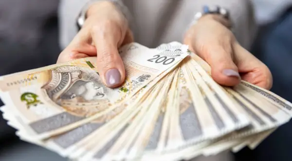 Dłonie trzymające plik banknotów 200 zł. Czy to odpowiedź na pytanie, ile zarabia menedżer hotelu?