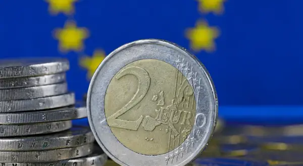 Monety euro na tle flagi UE. Tak, w Estonii jest euro, to waluta obowiązująca od 2011 roku.