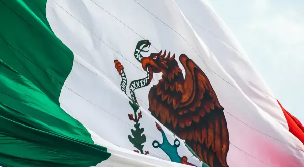 Meksykańska flaga z orłem połykającym węża. Czy Meksyk jest niebezpieczny dla turystów? Wiele zależy od regionu i zachowania.