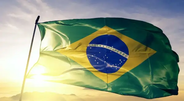 Flaga Brazylii powiewa na tle nieba. Czy jest waluta o nazwie real? Tak, to brazylijska waluta.