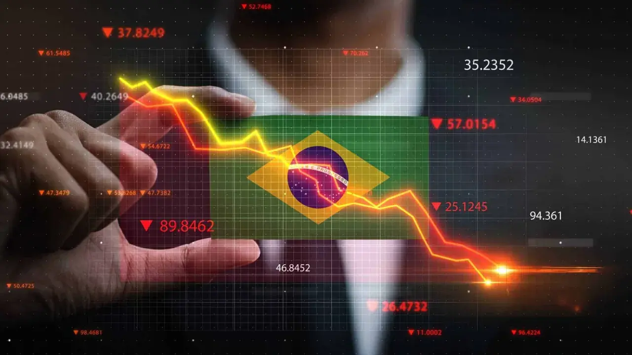 Ręka trzyma flagę Brazylii na tle wykresu finansowego. Kiedyś waluta Brazylii, real, doświadcza spadków.