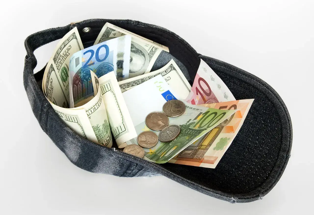 Czapka wypełniona banknotami dolarów i euro, a także monetami. Czy w Turcji można płacić dolarami? Ta wizualizacja sugeruje, że tak, bo pieniądze są wszędzie!