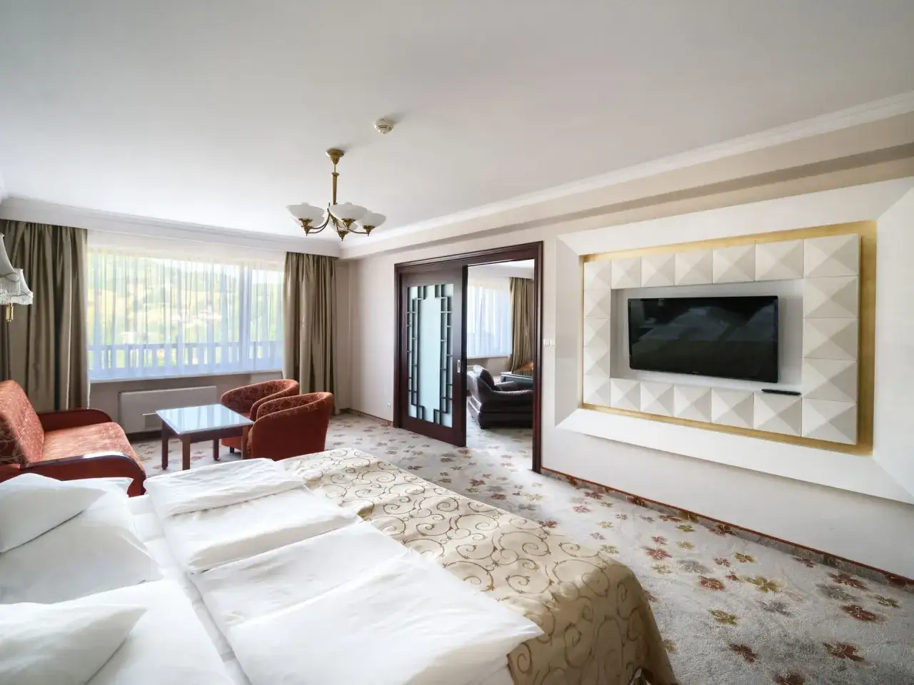 Wygodny pokój hotelowy z widokiem na góry. Ile pokoi ma hotel Gołębiewski w Wiśle? Ten pokój oferuje przestrzeń i komfort.