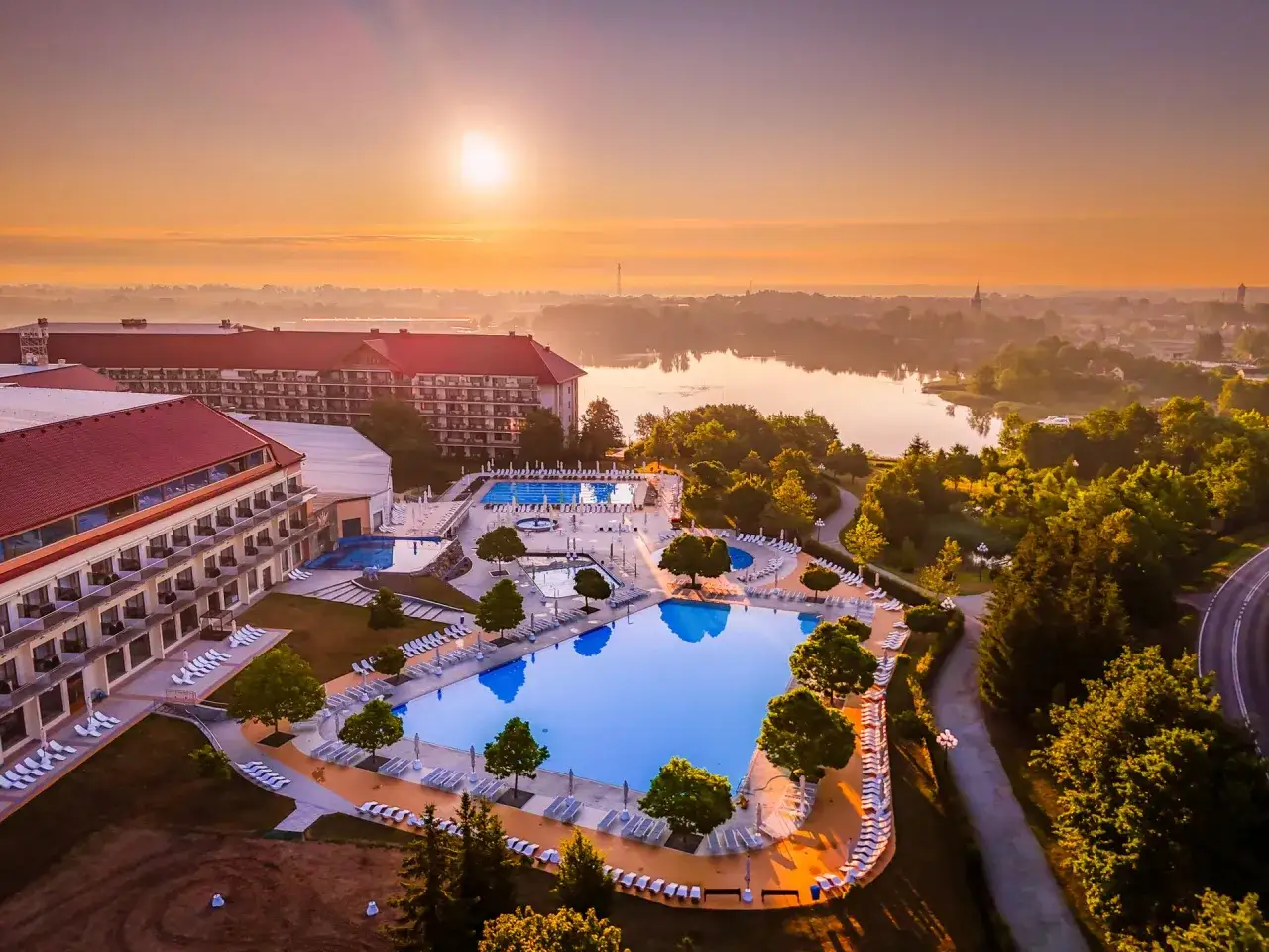 Widok z lotu ptaka na kompleks basenów i hotel Gołębiewski o wschodzie słońca. W Polsce jest wiele hoteli Gołębiewskich.