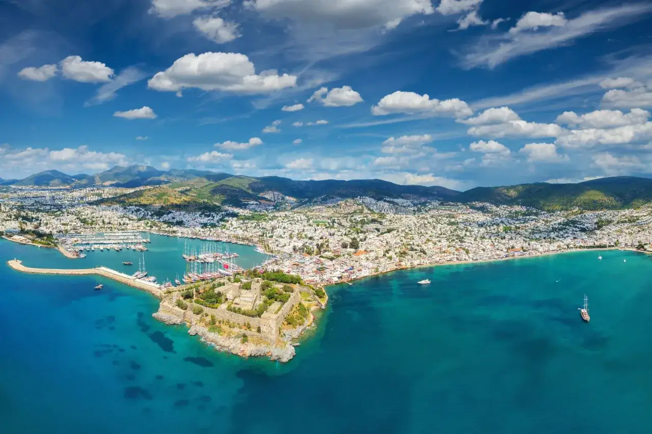 Widok na zamek i port w Bodrum, idealne miejsce, gdzie do Turcji. Białe domy, błękitne morze i góry w tle.