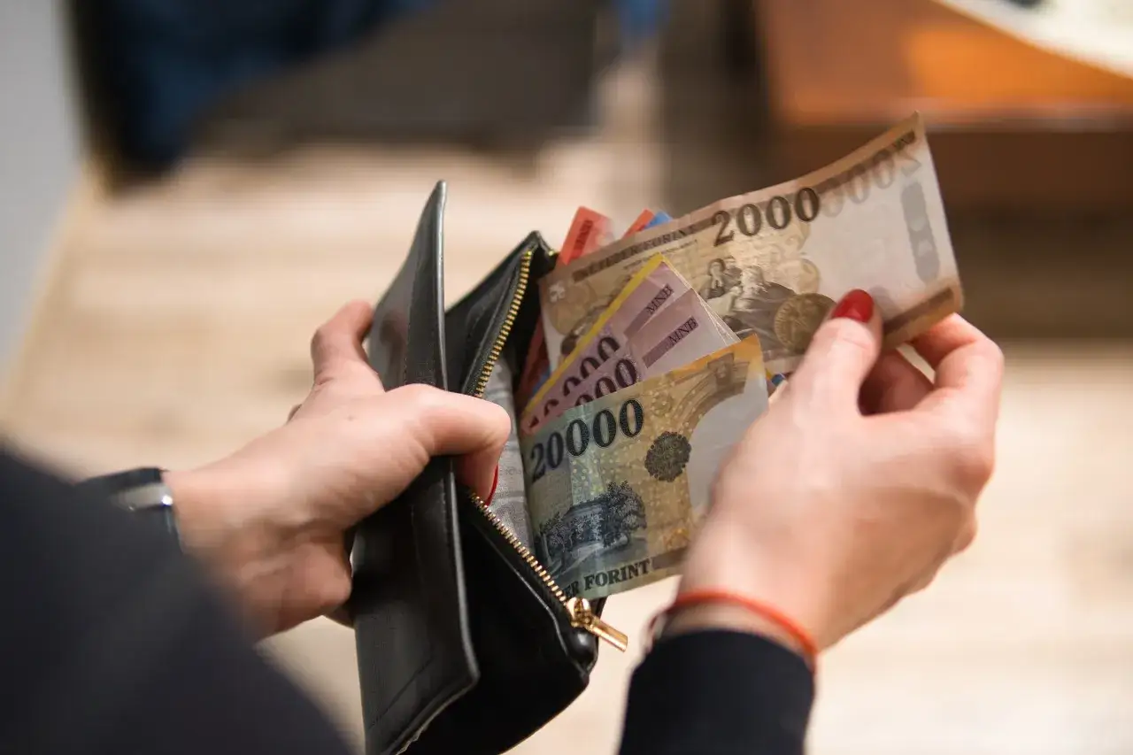 Ręce wyciągają z portfela węgierskie forinty. Czy na Węgrzech można płacić euro? Nie, tam obowiązuje lokalna waluta.