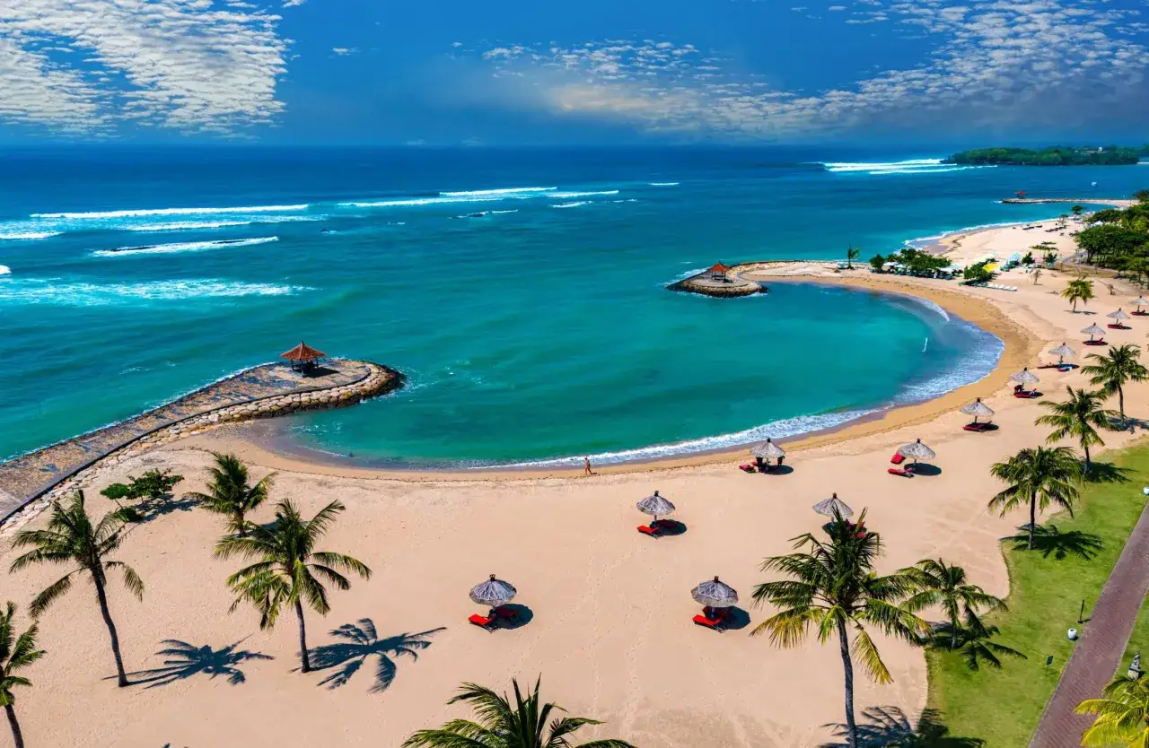 Idealny czas na wakacje na Bali: piaszczysta plaża, turkusowa woda, palmy i słońce.