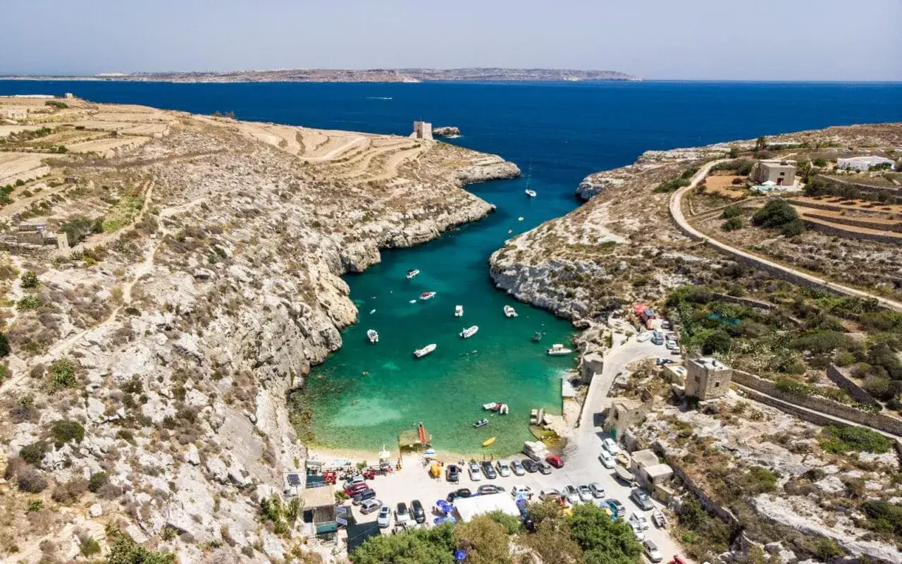 Malta, z turkusową wodą i łodziami, idealne miejsce, by sprawdzić, kiedy lecieć na Maltę.
