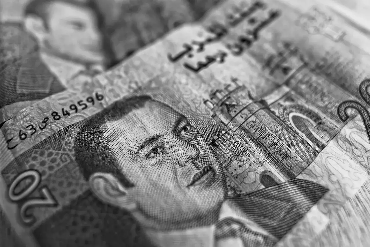 Monety i banknoty marokańskie, w tym 20 dirhamów. Zastanawiasz się, jaką walutę zabrać do Maroka? Dirhamy to lokalna waluta.