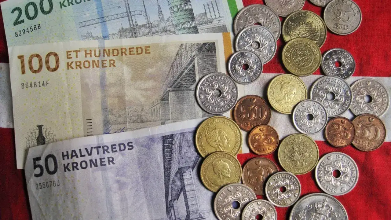 Dania ma walutę zwaną korona duńska. Na zdjęciu widać banknoty 100 i 50 koron oraz różne monety.