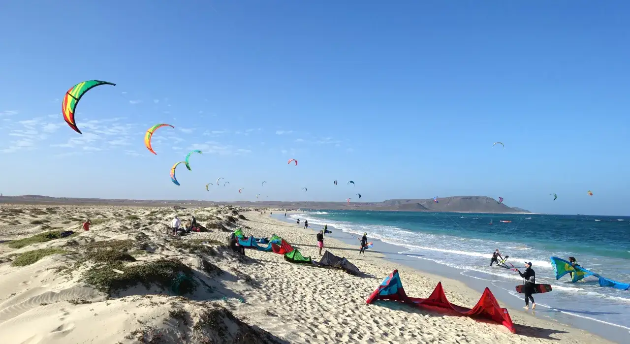 Idealny czas, kiedy lecieć na Wyspy Zielonego Przylądka to okres z silnymi wiatrami, idealnymi do kitesurfingu, co widać na tym zdjęciu z kolorowymi latawcami.