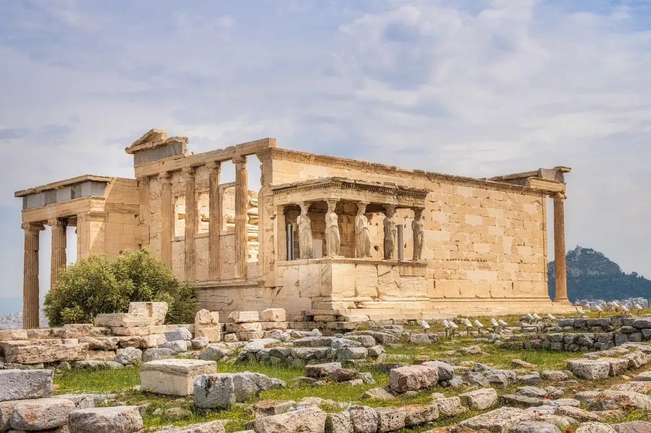 Erechtheion na Akropolu, z jego kariatydami, budzi pytania: czy Ateny są bezpieczne? Ruiny i starożytna architektura na tle błękitnego nieba.