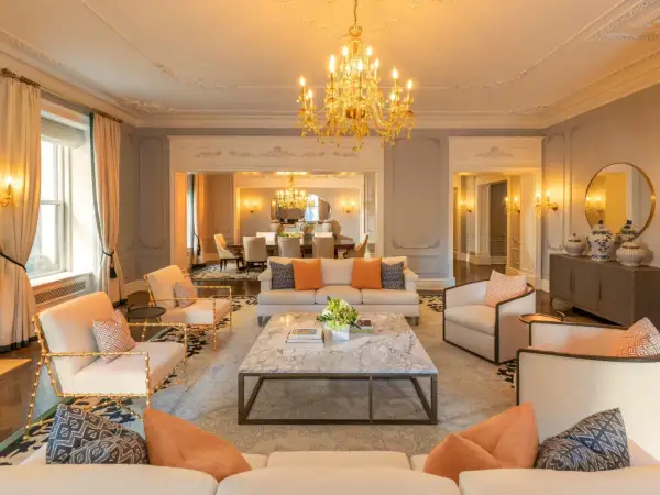 Elegancki salon z marmurowym stolikiem i złotym żyrandolem. Zastanawiasz się, ile kosztuje doba w hotelu Plaza w Nowym Jorku?