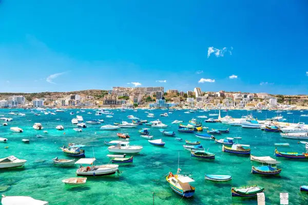 Malta w lutym: słoneczna zatoka pełna łodzi, idealna na spacer.