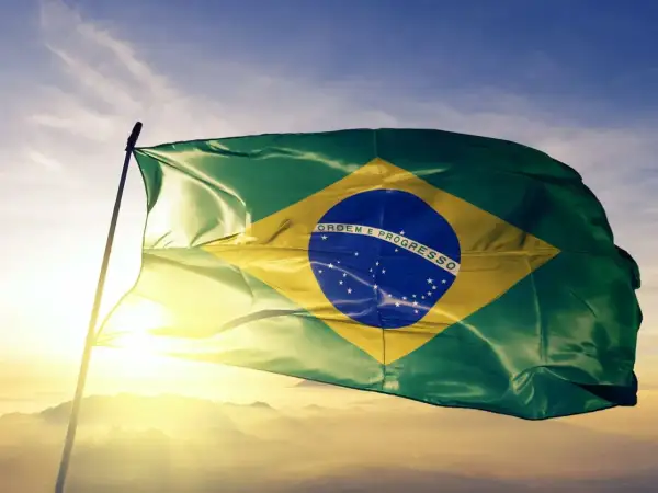 Flaga Brazylii powiewa na tle nieba. Czy jest waluta o nazwie real? Tak, to brazylijska waluta.